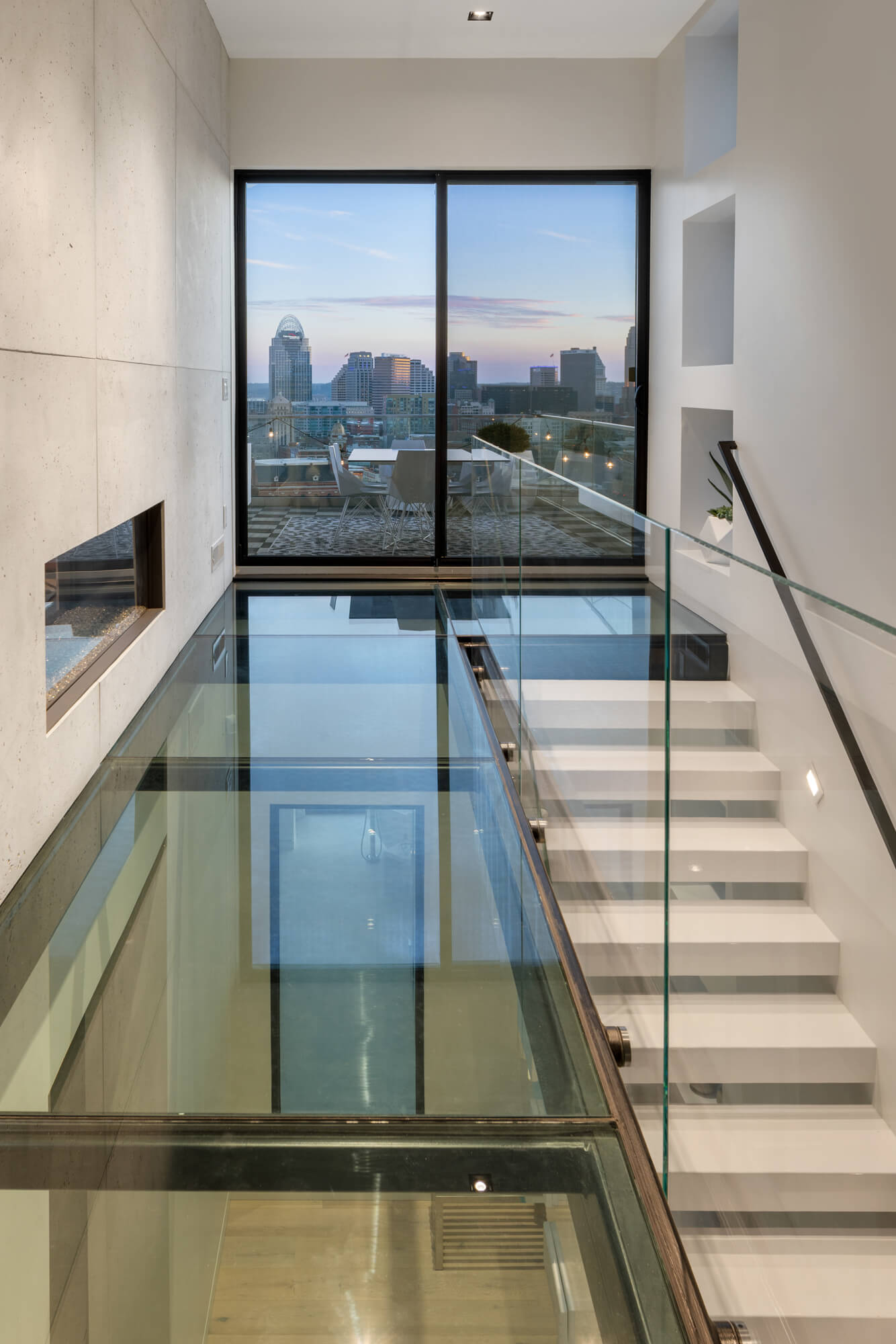 Custom Starway and glass floor hallway with Cincinnati Skyline views by Premiere Interior Designer, RM Interiors