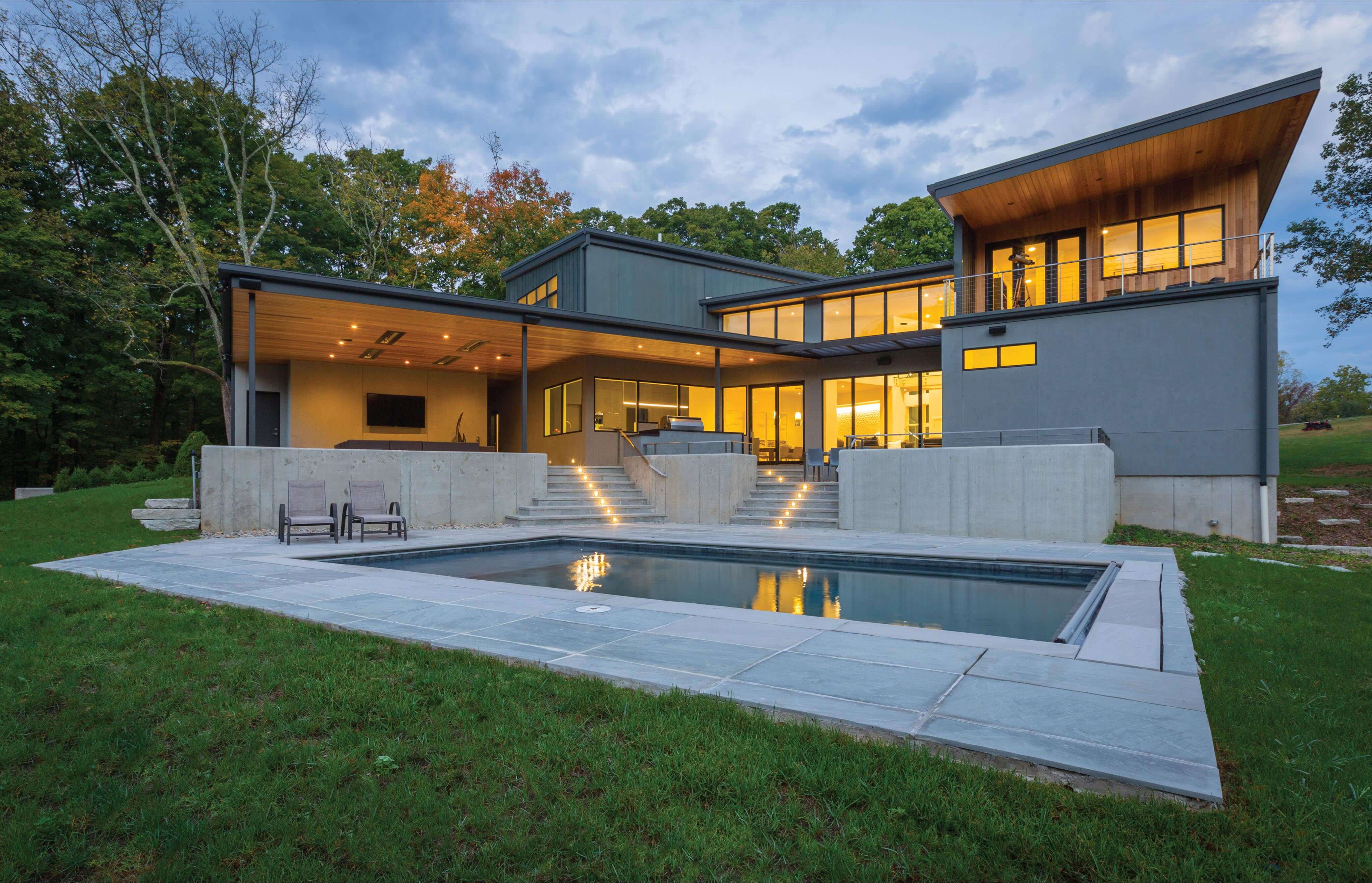 Rear exterior photo of the property featuring multiple decks and private pool. Interiors designed by Interior Designer, RM Interiors.